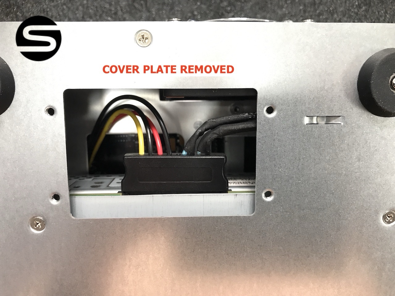 The inspection panel with the cover plate removed, exposing the drive connector and cabling inside the chassis